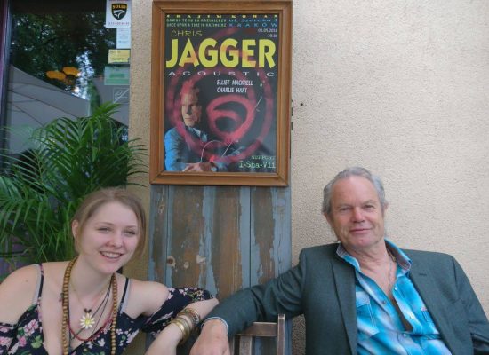 I-Sha-Vii and Chris Jagger sitting next to a poster with their names